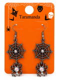 A pair of Halloween dangling earrings displayed on an orange backing card. Each earring has an antiqued silver spiderweb dangle with a small iridescent rhinestone in the center and a dangling spider charm with a rhinestone body.