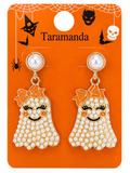 A pair of Taramanda brand Halloween ghost drop earrings on an orange display card. The earrings feature a gold-tone setting with white faux pearls, a small orange bow, and a ghost body covered in white rhinestones with black embroidered facial features.