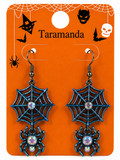 A pair of Halloween-themed dangling earrings on an orange display card. The earrings feature dark metallic spiderwebs with small iridescent rhinestones in the center and matching spider charms below.