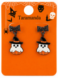 A pair of Halloween-themed dangle earrings displayed on an orange retail card. Each earring has a black glittery bow, a black witch hat, and a white ghost pumpkin charm.