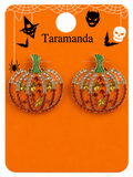 A pair of Halloween pumpkin stud earrings displayed on an orange card. The earrings are designed to look like pumpkins with green stems, outlined with clear rhinestones, and filled with red, orange, and yellow faceted rhinestones.