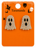 A pair of gold ghost stud earrings covered in clear rhinestones with black eyes and mouths, displayed on an orange Halloween-themed card labeled Taramanda.