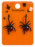 A pair of Halloween spider earrings on an orange display card. The earrings have black spider bodies and legs with faceted red gemstone abdomens.