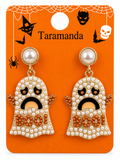 A pair of Halloween ghost drop earrings displayed on an orange retail card. The earrings have a gold-tone setting, white faux pearls, and orange rhinestones spelling 'BOO!' with black facial details.
