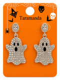 A pair of silver-toned ghost drop earrings covered in clear rhinestones, mounted on an orange Halloween-themed card with spiderwebs, bats, a witch hat, and the brand name Taramanda.