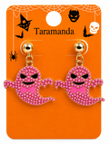 A pair of pink ghost-shaped stud earrings covered in small rhinestones with gold-tone posts, displayed on an orange Halloween-themed card labeled Taramanda.